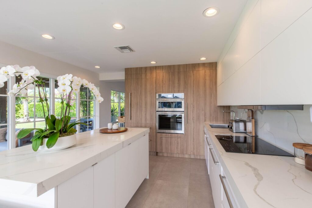 Bright modern kitchen with white island and orchids